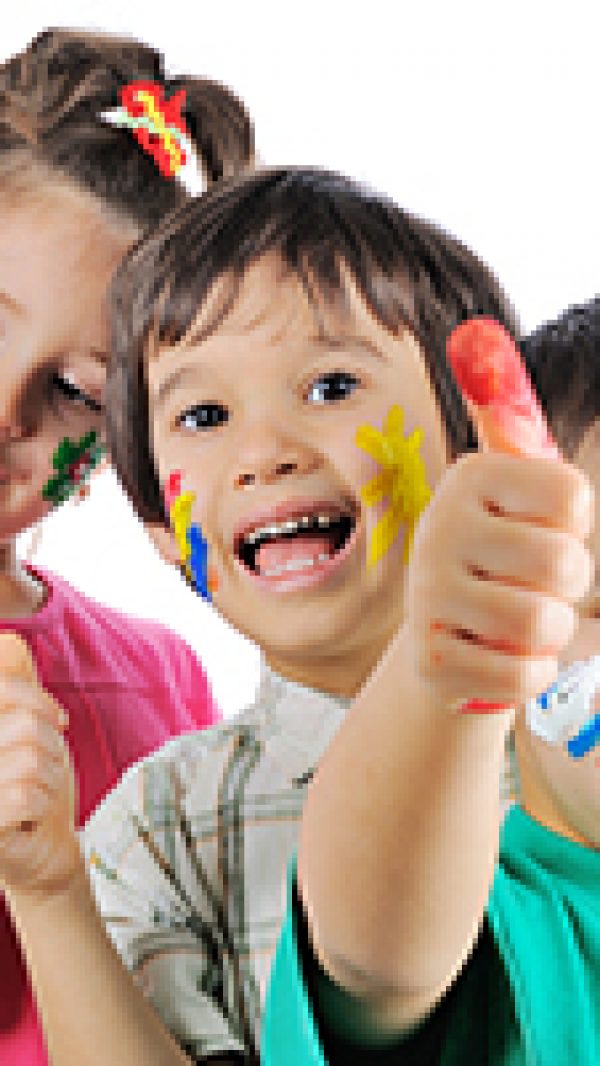 Messy children with paint on their hands and faces with thumbs u