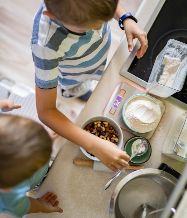 Top view baby brothers kids cooking dessert together use fresh healthy ingredients at modern minimalistic kitchen. Cute male children preparation sweet baking mixing different nuts, flour and sugar