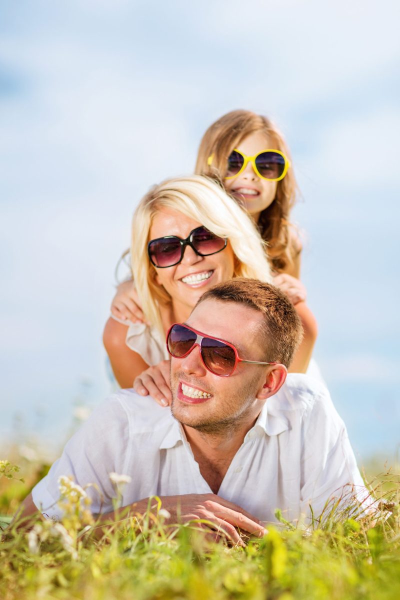 summer holidays, children and people concept - happy family with blue sky and green grass